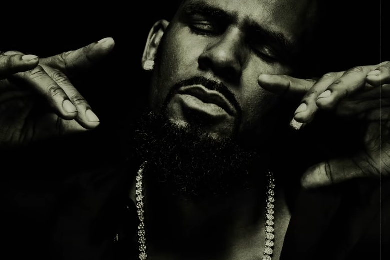 A black and white photo of R. Kelly closing his eyes and moving his hands